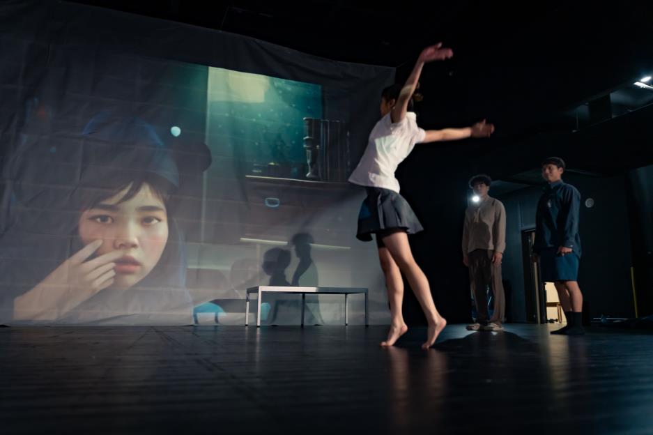 舞台回到校園最後一天，課桌椅重現、書本翻頁化作節拍，黑板與投影交織迷幻光影，彷彿走進青春滿溢的畢業現場。